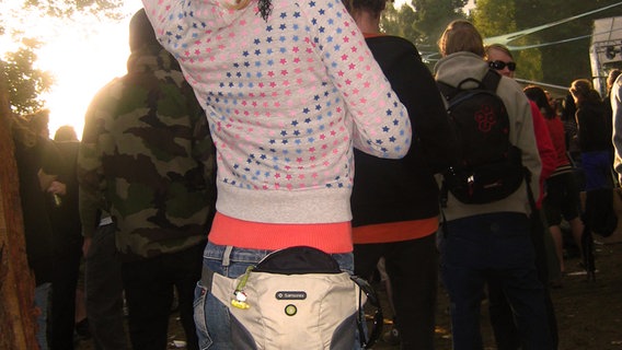 Eine Frau auf einem Festival trägt eine Bauchtasche. © Klaus Klee / photocase.de 