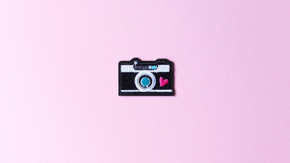 Ein Nähsticker in Form einer Kamera auf rosa Hintergrund. © go2 / photocase.de Foto: go2 / photocase.de