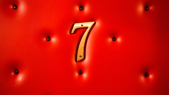 Die Zahl sieben in gold auf rotem Leder. © David Dieschburg / photocase.de Foto: David Dieschburg