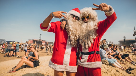 Zwei Männer tragen Weihnachtsmann-Kostüme. © NDR Foto: Benjamin Hüllenkremer