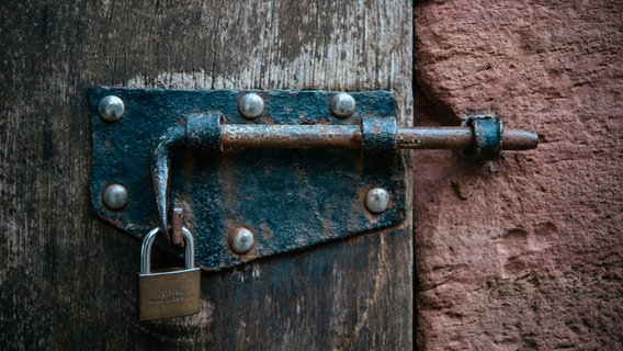 Eine alte Tür mit einem Vorhängeschloss. © picture alliance/Jan Haas Foto: Jan Haas
