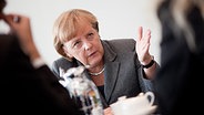 Angela Merkel im Interview. Gesprächspartner unscharf im Anschnitt. © dpa bildfunk 