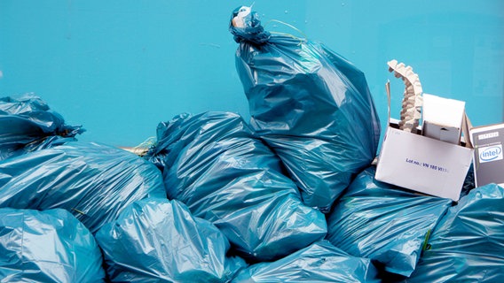 Viele blaue Müllsäcke aufeinandergestapelt, darauf stehen einige Kartons. ©  picture alliance / JOKER Foto:  Karl-Heinz Hick