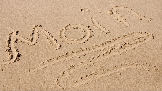 Das Wort moin geschrieben im Sand am Strand © Fotolia.com Foto: O.K.