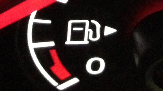 Ein Pfeil leuchtet neben dem Zapfsymbol im Auto-Cockpit.  