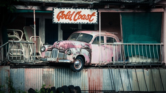 Zu sehen ist ein altes Auto, das in einem Haus steckt. © derjoachim / photocase.de Foto: derjoachim