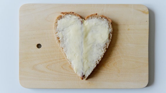 Zu sehen ist eine Scheibe Brot mit Butter in Herzform. © picture alliance / Frank May Foto: Frank May