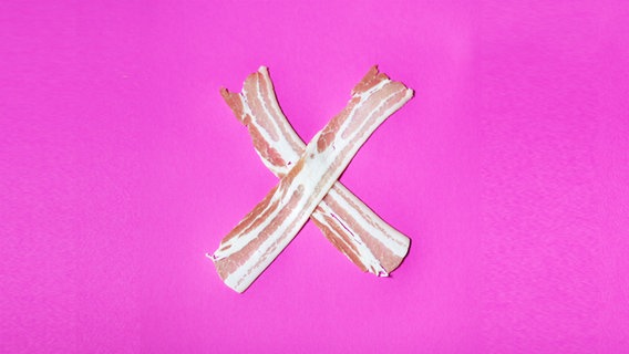 Zu sehen ist ein X aus Schinken vor einem pinken Hintergrund. © CL. / photocase.de Foto: CL.