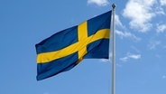Die schwedische Nationalflagge weht an einem Mast im Wind. © picture alliance/dpa Foto: Daniel Kalker