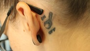 Stefanie Heinzmann zeigt ihr Tattoo hinter dem linken Ohr. © NDR 