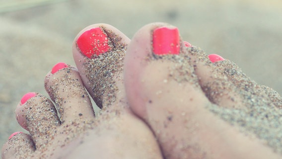 Füße im Sand mit rosafarbenem Nagellack. © photocase.de Foto: meina mija