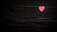 Ein kleines rotes Herz auf Holz. © Photocase / Maspi Foto: Maspi