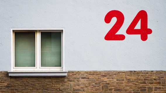 Eine rote Zahl 24 auf einer Hauswand neben einem Fenster. © Photocase Foto: Birdys