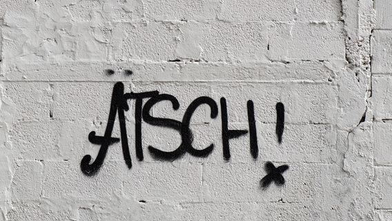 Auf eine weiße Wand ist das Wort "Ätsch" gesprayt. © HerrSpecht / photocase.de Foto: HerrSpecht / photocase.de