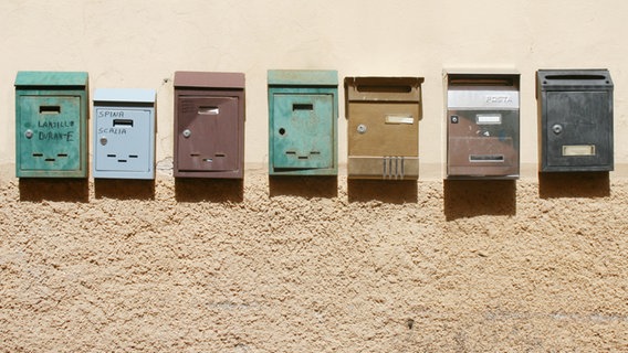 Mehrere Briefkästen hängen an einer hellen Wand nebeneinander. © krockenmitte / photocase.de Foto: krockenmitte / photocase.de