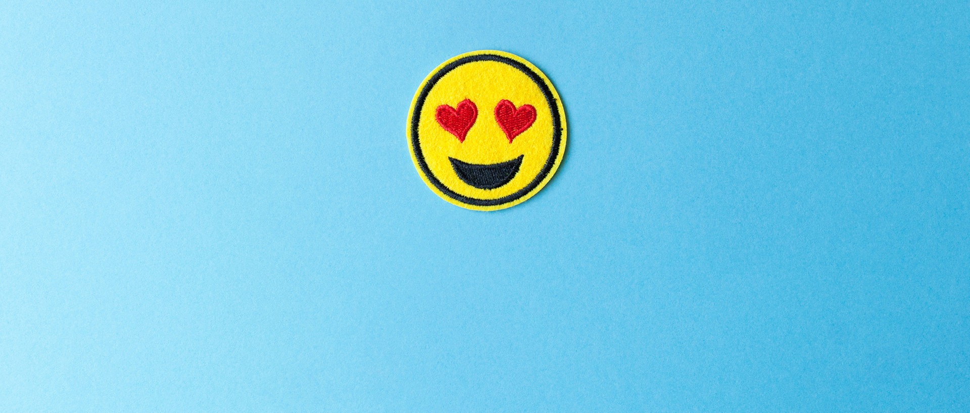 Ein Emoji mit Herzchen-Augen auf hellblauem Hintergrund., © go2 / photocase.deFoto: go2 / photocase.de