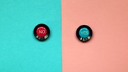 Ein Knopf mit "No" und ein Knopf mit "Yes" auf blauem und rosa Hintergrund. © LBP / photocase.de Foto: LBP