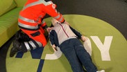 Das Bild zeigt einen Notfallsanitäter mit einer Reanimationspuppe. © N-JOY Foto: N-JOY