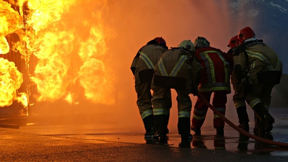 Mehrere Feuerwehrleute löschen einen Brand. © uwy.ch / photocase.de Foto: uwy.ch / photocase.de