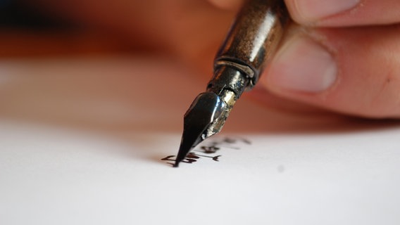 Eine Hand schreibt mit einem Füller auf weißem Papier. © madphoenix* / photocase.de Foto: madphoenix* / photocase.de