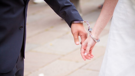 Ein Ehepaar ist mit Handschellen miteinander verbunden. © David Dieschburg / photocase.de Foto: David Dieschburg / photocase.de
