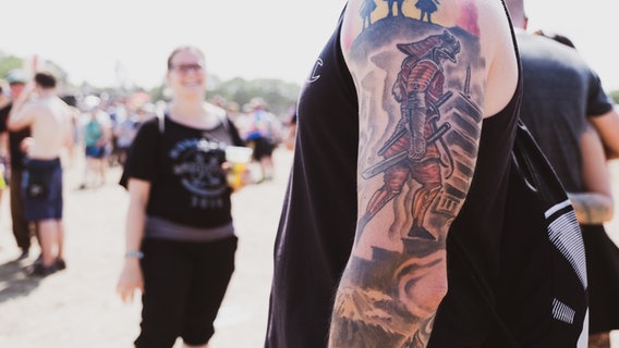Ein Besucher des Hurricane Festivals 2019 zeigt sein Tattoo. © NDR/N-JOY Foto: Benjamin Hüllenkremer