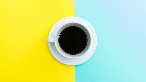Eine Tasse Kaffee auf blauem und gelbem Hintergrund. © obeyleesin / photocase.de Foto: obeyleesin