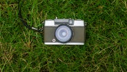 Eine alte Kamera liegt im Gras. © PxPhotos / photocase.de Foto: PxPhotos / photocase.de
