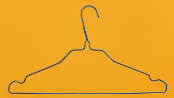 Ein leerer Kleiderbügel vor gelbem Hintergrund. © cydonna / photocase.de Foto: cydonna
