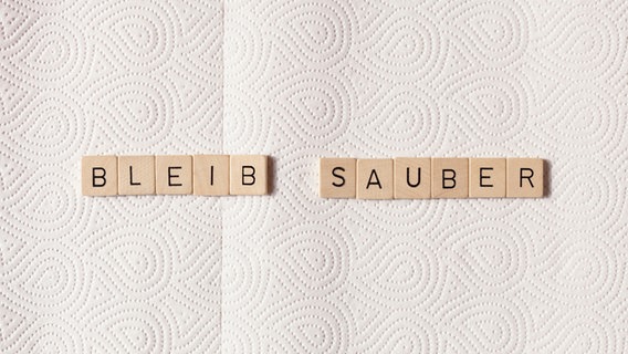 Auf einem Tuch liegen Buchstaben, die die Wörter "Bleib sauber" formen. © go2 / photocase.de 