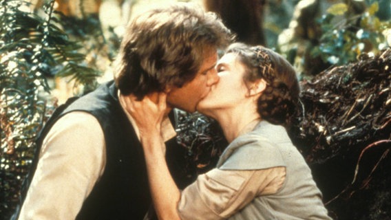 Szenenbild aus Stars Wars: Han Solo und Prinzessin Leia küssen sich. © imago/EntertainmentPictures 