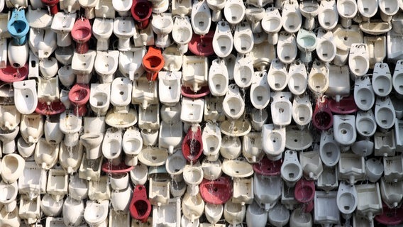 Zu sehen ist ein chinesisches Kunstprojekt,bei dem eine Wand aus diversen Toillettenschüsseln gebaut wurde. © imago / China Foto Press 