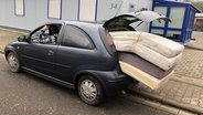 Polizei-Foto: Ein Auto ist vollgepackt mit vier Matratzen, die von einem verknoteten USB-Kabel gehalten werden. © Polizeidirektion Kaiserslautern 