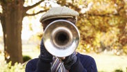 Ein Junge spielt Trompete. Sein Gesicht ist von der Trompete verdeckt. © imago/Science Photo Library Foto: Science Photo Library