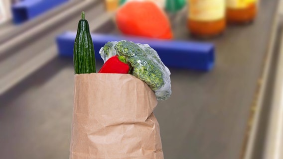 Eine Tüte mit Gemüse auf einem Kassenband, dahinter ein Warentrenner. © xOlgaGx Panthermedia Foto: xOlgaGx