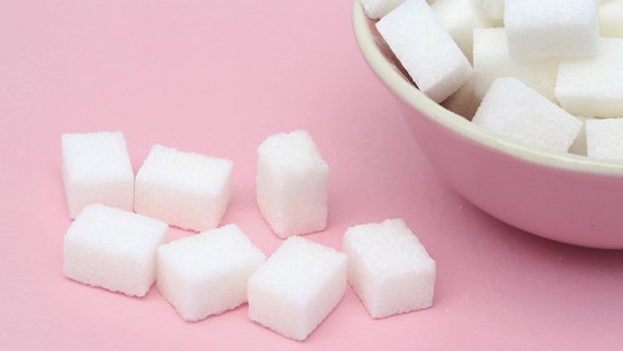 Zuckerwürfel vor pinkem Hintergrund © imago/PPE 