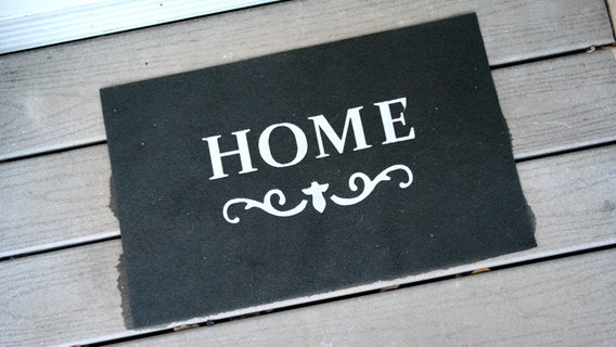 Eine Fußmatte mit der Aufschrift "Home". © picture alliance / R. Goldmann Foto: Ralph Goldmann