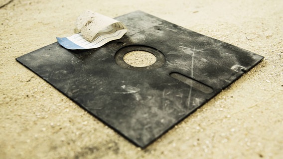 Eine alte und kaputte 8 Zoll-Diskette liegt im Sand. © imago/McPHOTO Foto: McPHOTO
