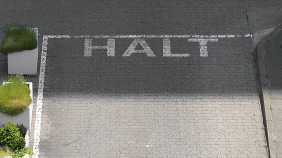 In einer Hofeinfahrt steht in Großbuchstaben "HALT" © Imago.de / Westend61 Foto: Westend61