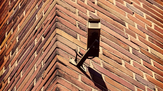 Eine Überwachungskamera hängt an einer Ziegelwand © imago/Westend61 Foto: Westend61