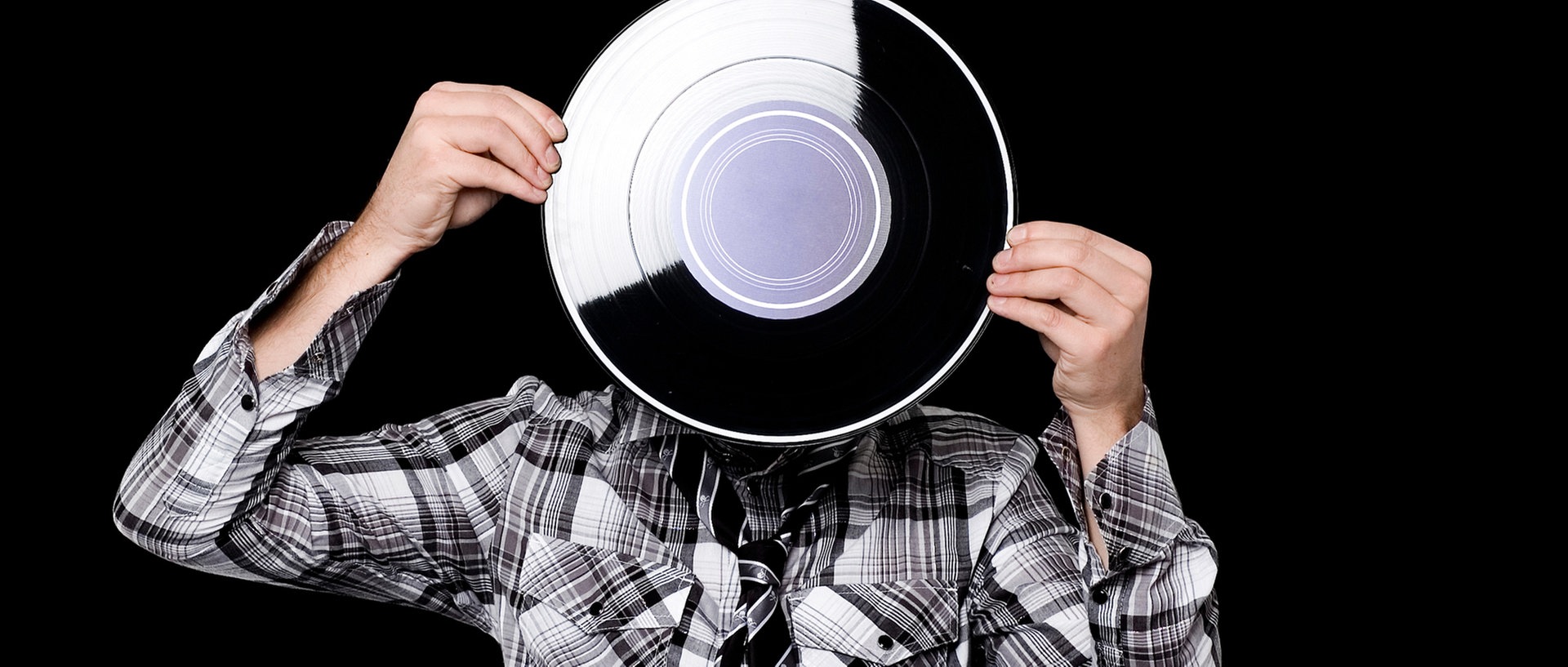 Ein Junge mit grauem Kapuzenpulli hält eine Schallplatte vor sein Gesicht., © PlainpictureFoto: Tabor Gus