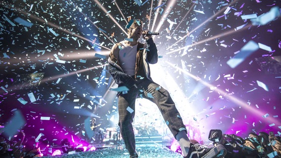 Dan Reynolds, der Sänger von Imagine Dragons, im Konfettiregen auf der Bühne. © picture alliance / Photoshot 
