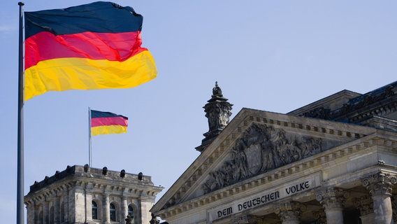 Das Bild zeigt eine deutsche Flagge und das Reichstagsgebäude © imago Foto: Westend61