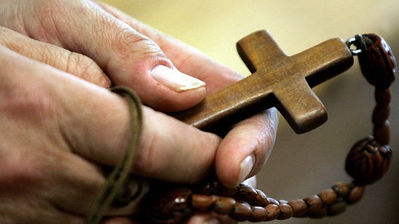 Hände halten ein Holzkreuz © picture-alliance/ dpa/dpaweb 