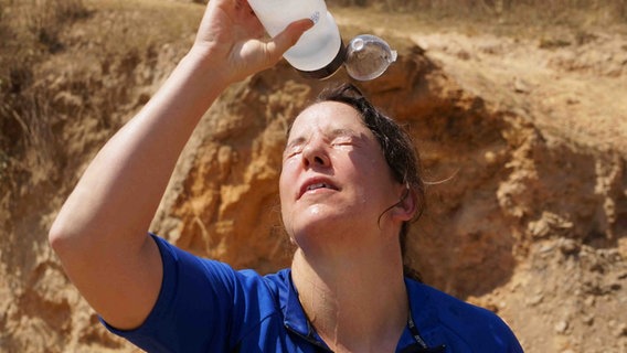 ARD-Korresponentin Ariane Reimers schüttet sich Wasser über den Kopf. © NDR Foto: Ariane Reimers