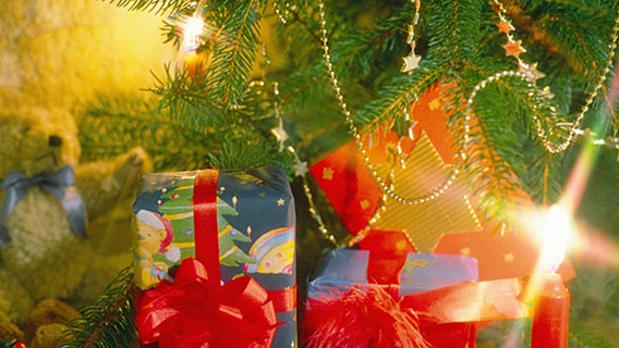 Geschenke liegen unter einem Weihnachtsbaum. © dpa 