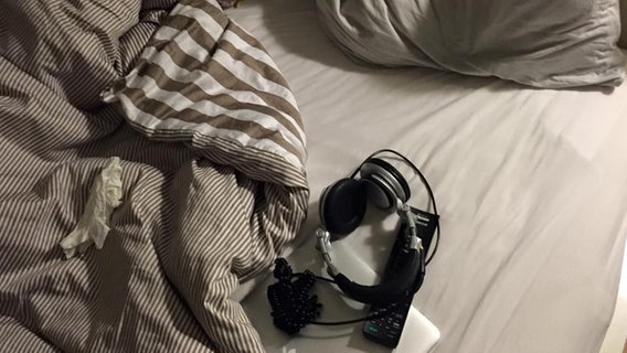 Ein Blick in Hardelands Bett zeigt Kissen, Decken, Kopfhörer und eine Fernbedienung  Foto: Jens HARDELAND