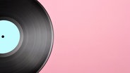 Eine Schallplatte liegt auf rosa Untergrund. © etorres69 / photocase.de Foto: etorres69 / photocase.de