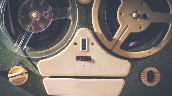Zu sehen ist ein alter Kassettenrecorder mit zwei Tonbändern. © photocase Foto: deyangeorgiev