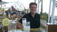 Nachrichtensprecher Christian Hinkelmann genießt ein Cocktail im Urlaub.  